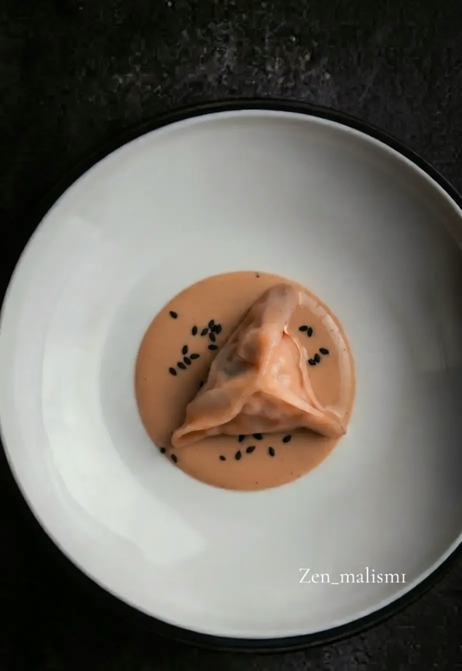 Dumpling in romige saus met zwarte sesam